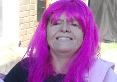 Pearlie wearing a bright purple wig at a Brighter Day event